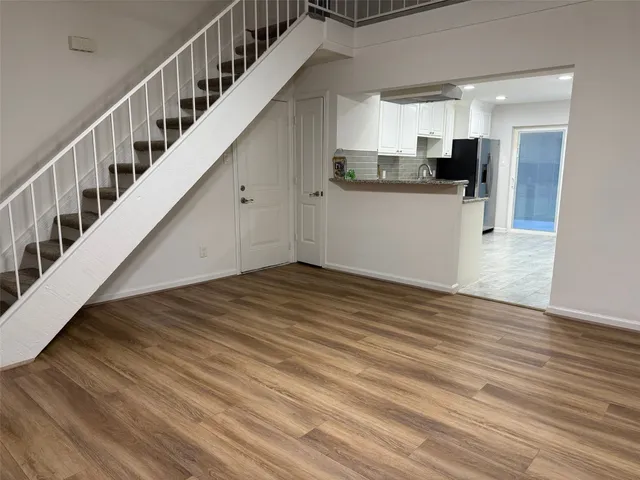 a view of a kitchen with wooden floor and electronic appliances