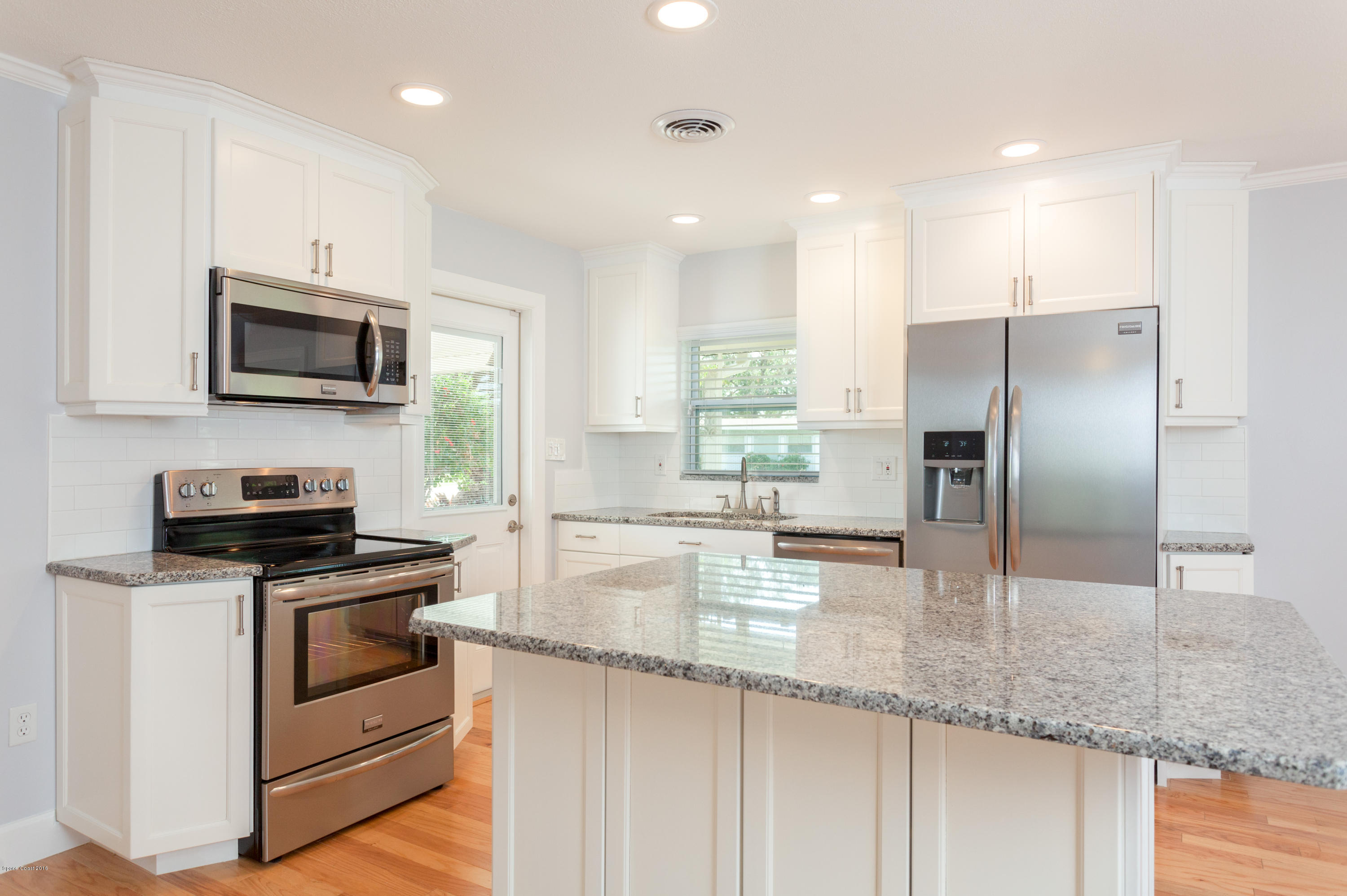 731 Java Road Cocoa Beach, FL 32931 - Photo 3 of 18 a kitchen with kitchen island granite countertop a sink a counter top space stainless steel appliances and cabinets