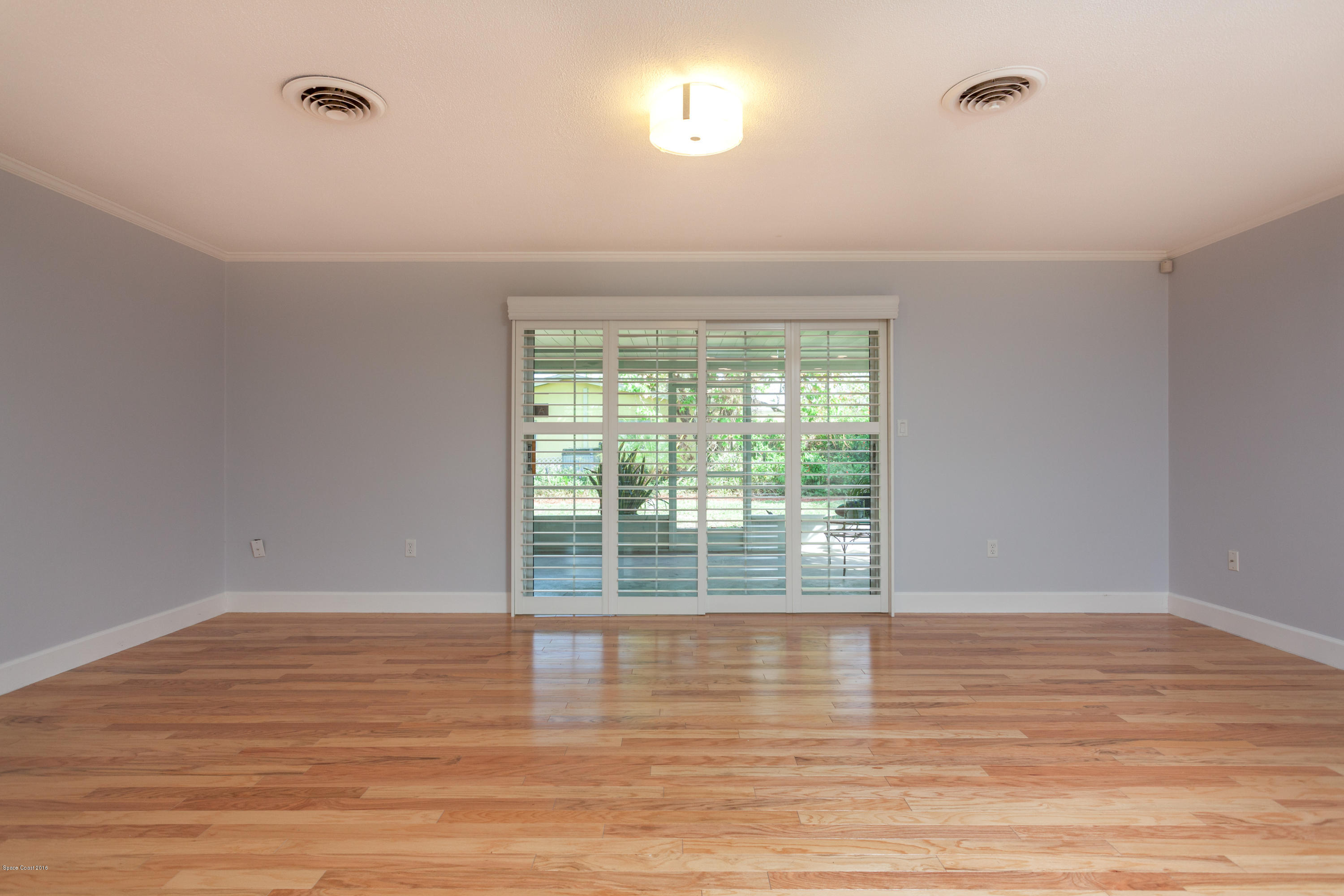 731 Java Road Cocoa Beach, FL 32931 - Photo 6 of 18 a view of empty room with wooden floor and fan