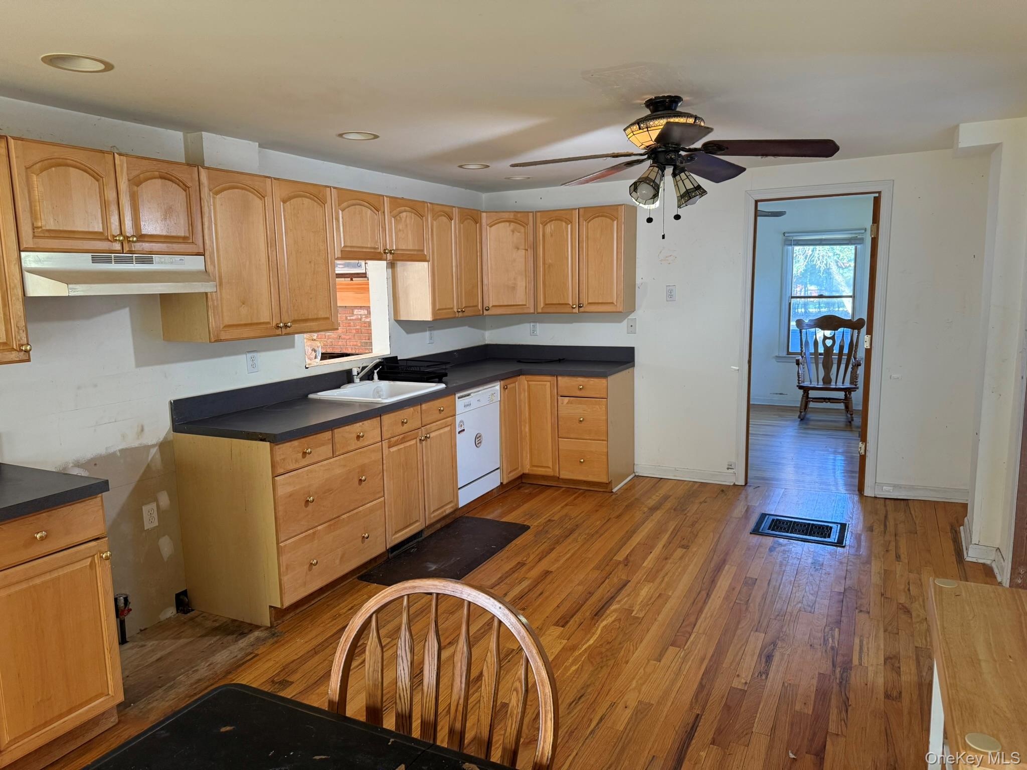 11005 Main Road East Marion, NY 11939 - Photo 9 of 26 a kitchen with granite countertop a sink cabinets wooden floor and stainless steel appliances