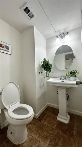 a bathroom with a toilet a sink and a mirror