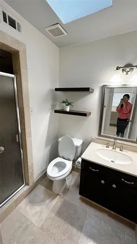 a bathroom with a double vanity sink toilet and mirror