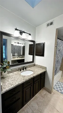a bathroom with a granite countertop sink and a mirror