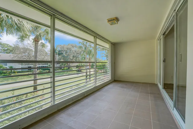 a view of a porch with wooden floor and a floor to ceiling window