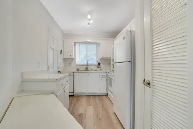 a kitchen with white cabinets and white appliances