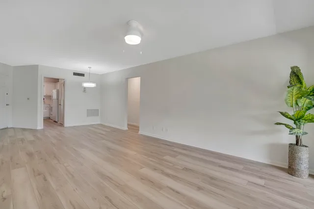 a view of an empty room with wooden floor