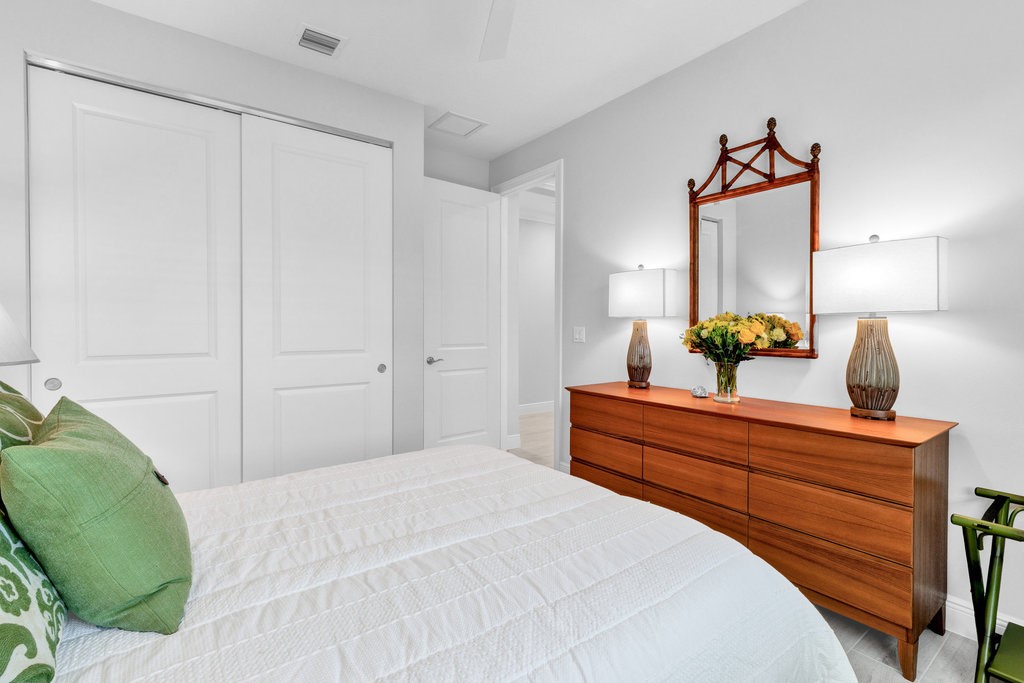 5594 Bent Pine Square Vero Beach, FL 32967 - Photo 21 of 35 a bedroom with a bed and a chandelier