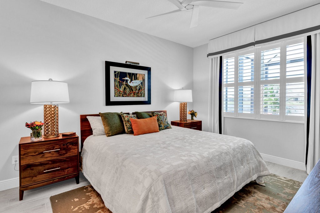 5594 Bent Pine Square Vero Beach, FL 32967 - Photo 23 of 35 a bedroom with a bed and a lamp on dresser