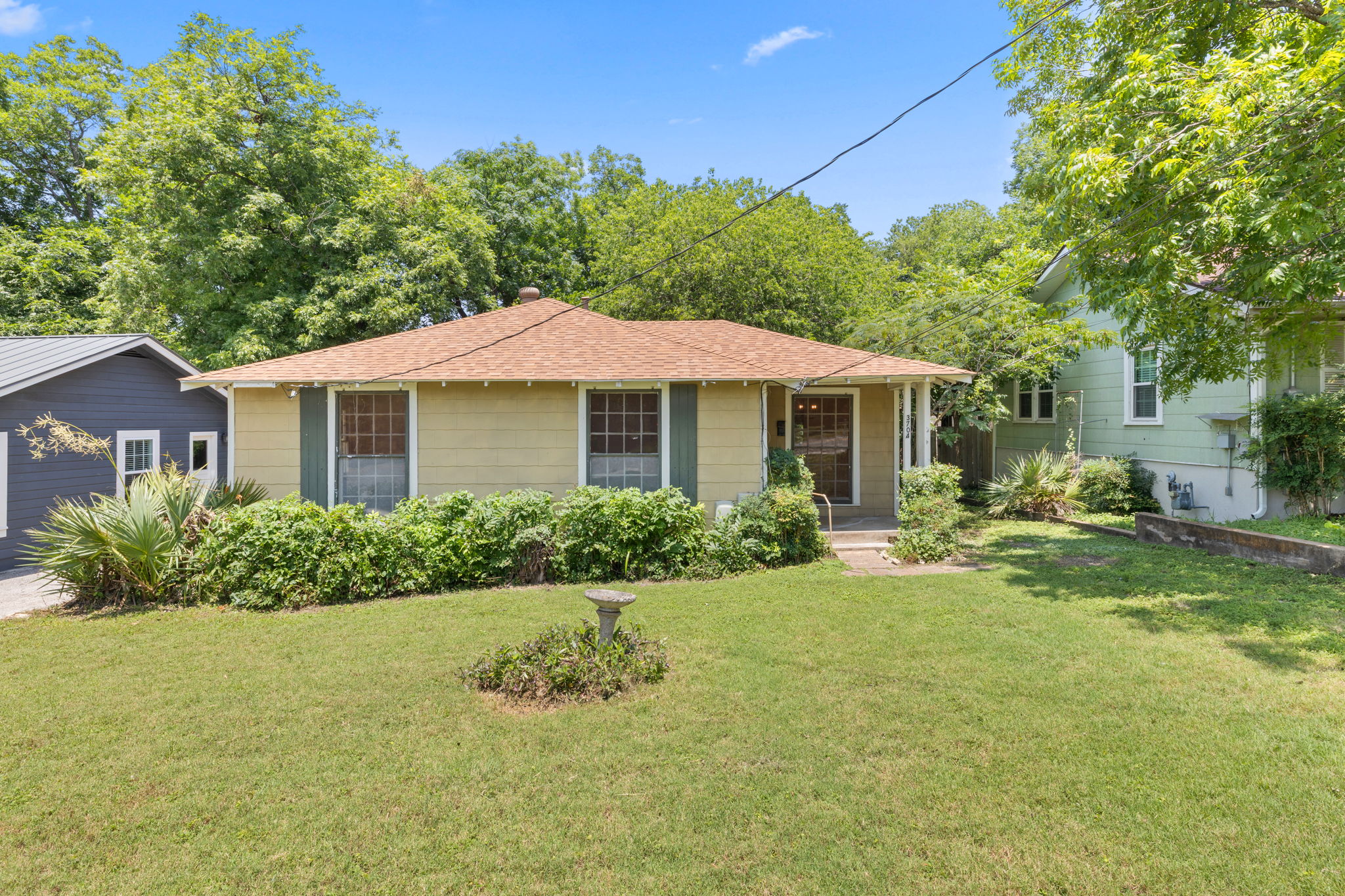 3704 Cherrywood Road Austin, TX 78722 - Photo 1 of 40 A well-maintained facade with inviting greenery frames this charming residence.