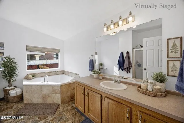 a bathroom with a granite countertop sink a large mirror and bathtub