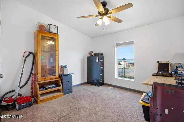 a view of a workspace with furniture and a window