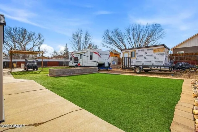 a front view of a building with a garden and trees
