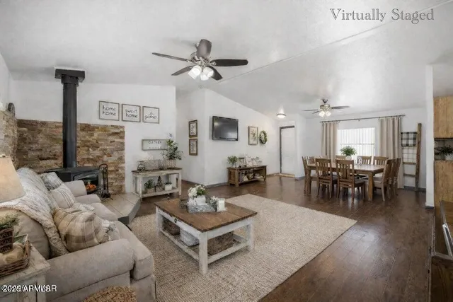 a living room with furniture and a view of kitchen