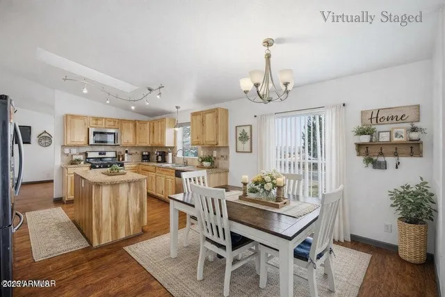 a kitchen with stainless steel appliances kitchen island granite countertop a table and chairs in it
