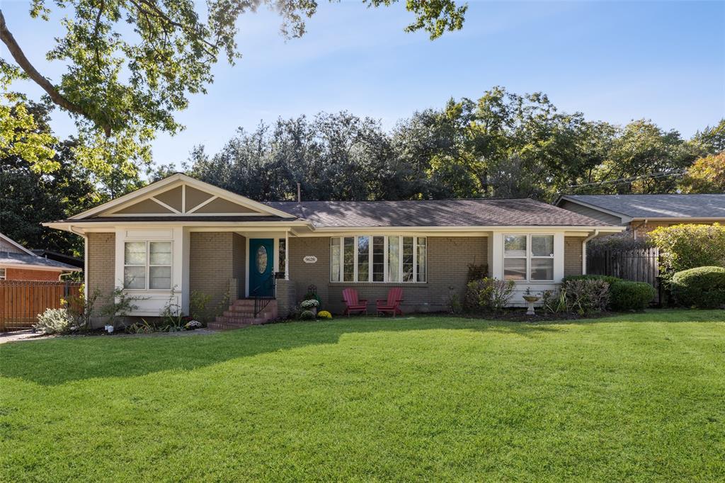 a front view of a house with a garden and trees