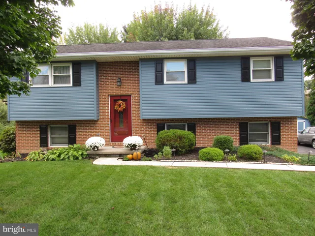 a front view of a house with a garden and plants