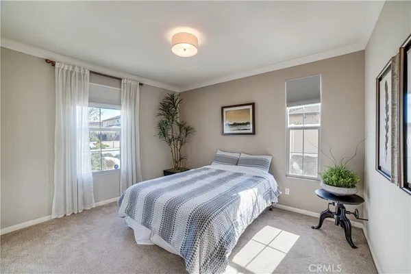 a bedroom with a bed and a potted plant
