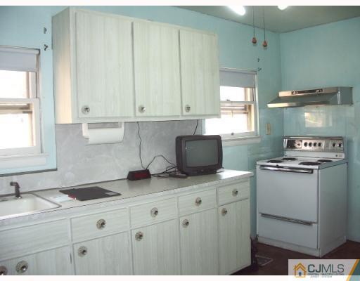 21 Wilcox Road New Brunswick, NJ 08901 - Photo 4 of 10 a kitchen with granite countertop white cabinets and white appliances