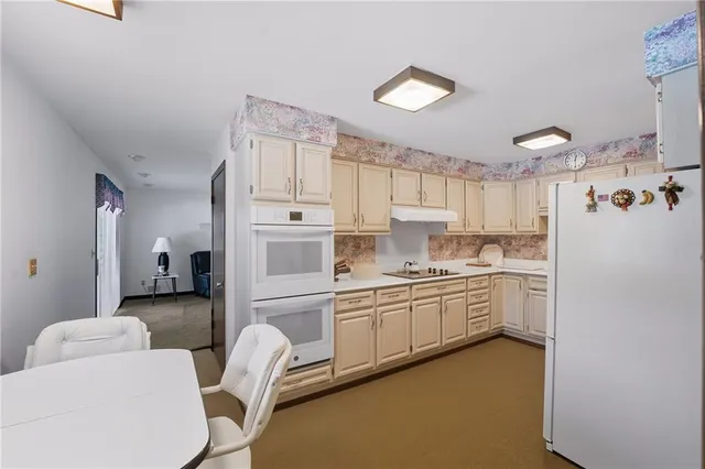 a kitchen with white cabinets and white appliances