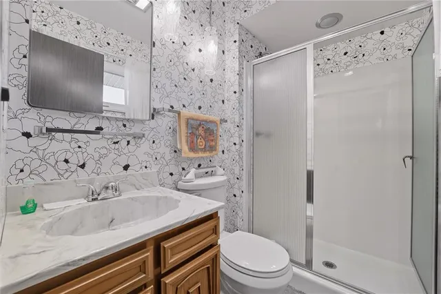 a bathroom with a granite countertop sink toilet a shower and a mirror