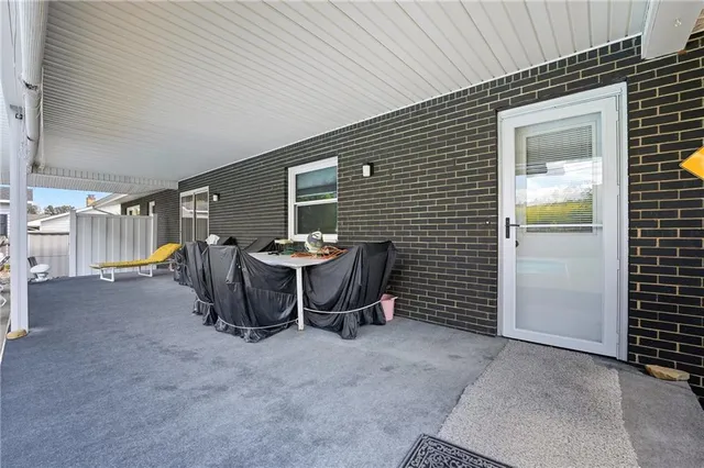 a view of a patio with table and chairs and a barbeque