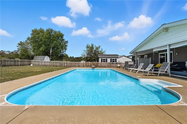 a swimming pool with outdoor seating and yard