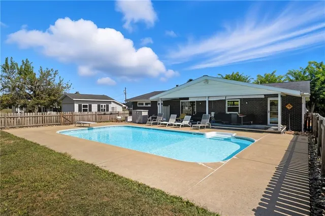 a front view of house with yard and swimming pool