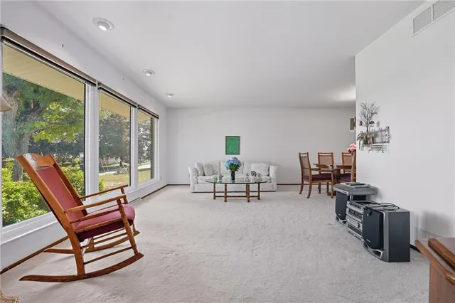 a living room with furniture and a floor to ceiling window