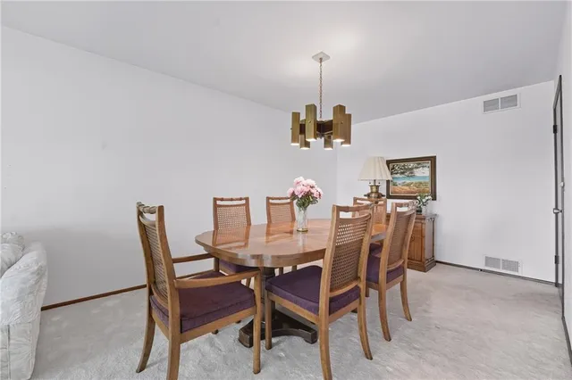 a view of a dining room with furniture and a chandelier