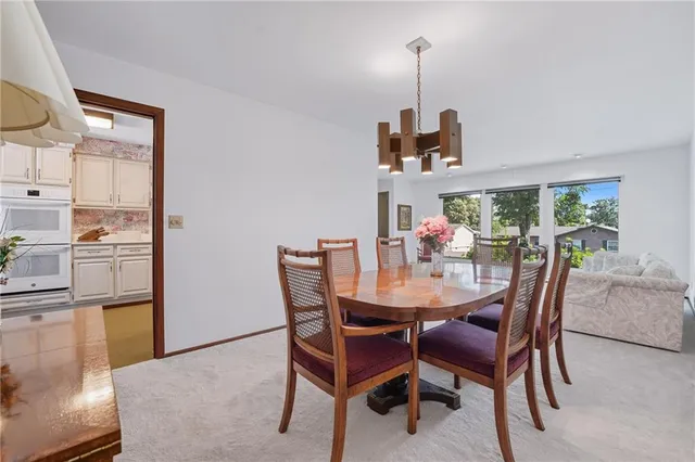 a dining room with furniture a chandelier and window