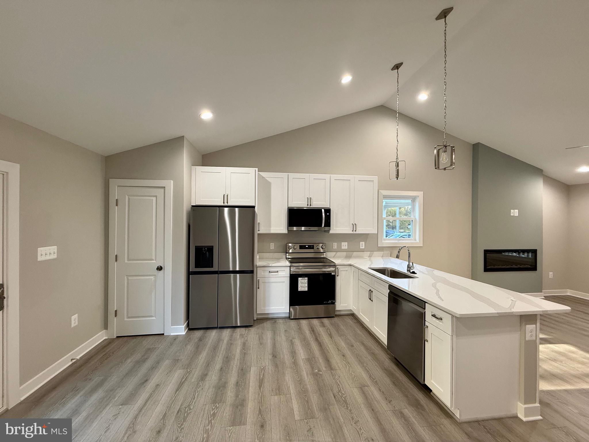 982 Mattox Avenue Colonial Beach, VA 22443 - Photo 13 of 53 a large kitchen with a stove a sink dishwasher a refrigerator and a oven with wooden floor