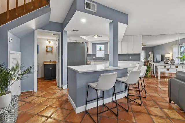 a kitchen with stainless steel appliances granite countertop a sink a stove a refrigerator with a dining table and chairs