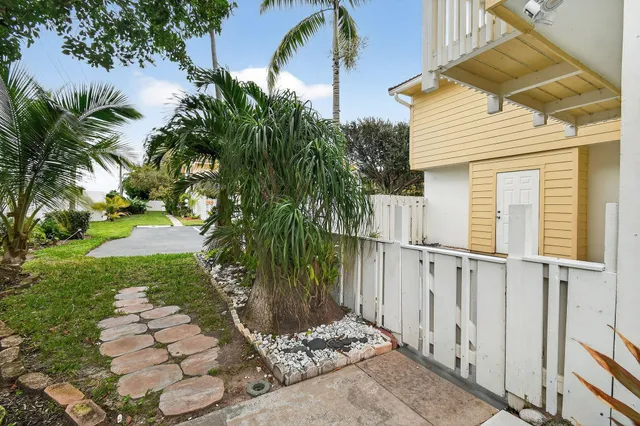 a view of a house with a small yard and wooden fence