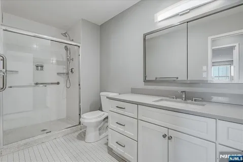 a bathroom with a granite countertop sink a toilet and shower