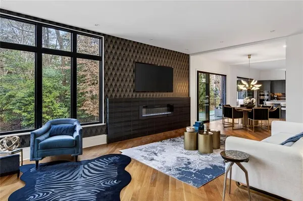 a bedroom with a bed a large window and wooden floor