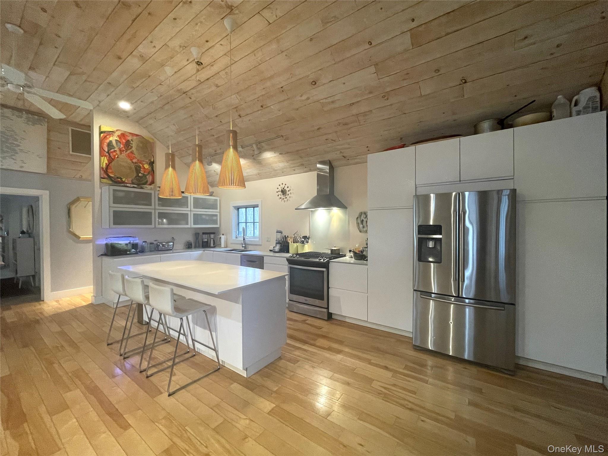 21 North Sea Road Southampton, NY 11968 - Photo 5 of 15 a kitchen with stainless steel appliances granite countertop a refrigerator a stove and a wooden floors