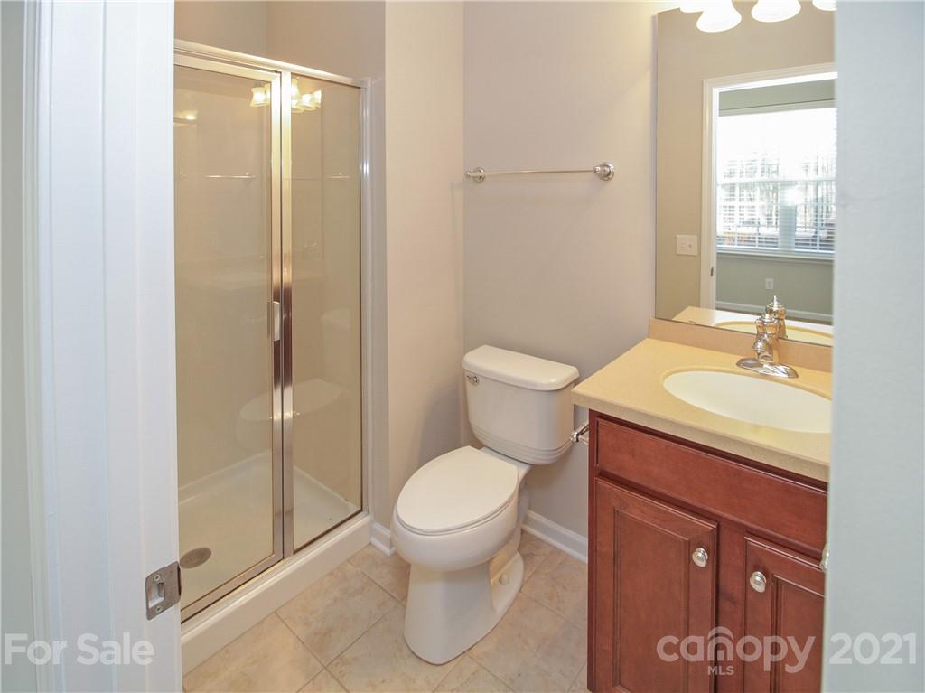 629 6th Baxter Crossing Fort Mill, SC 29708 - Photo 26 of 31 a bathroom with a granite countertop toilet sink and shower