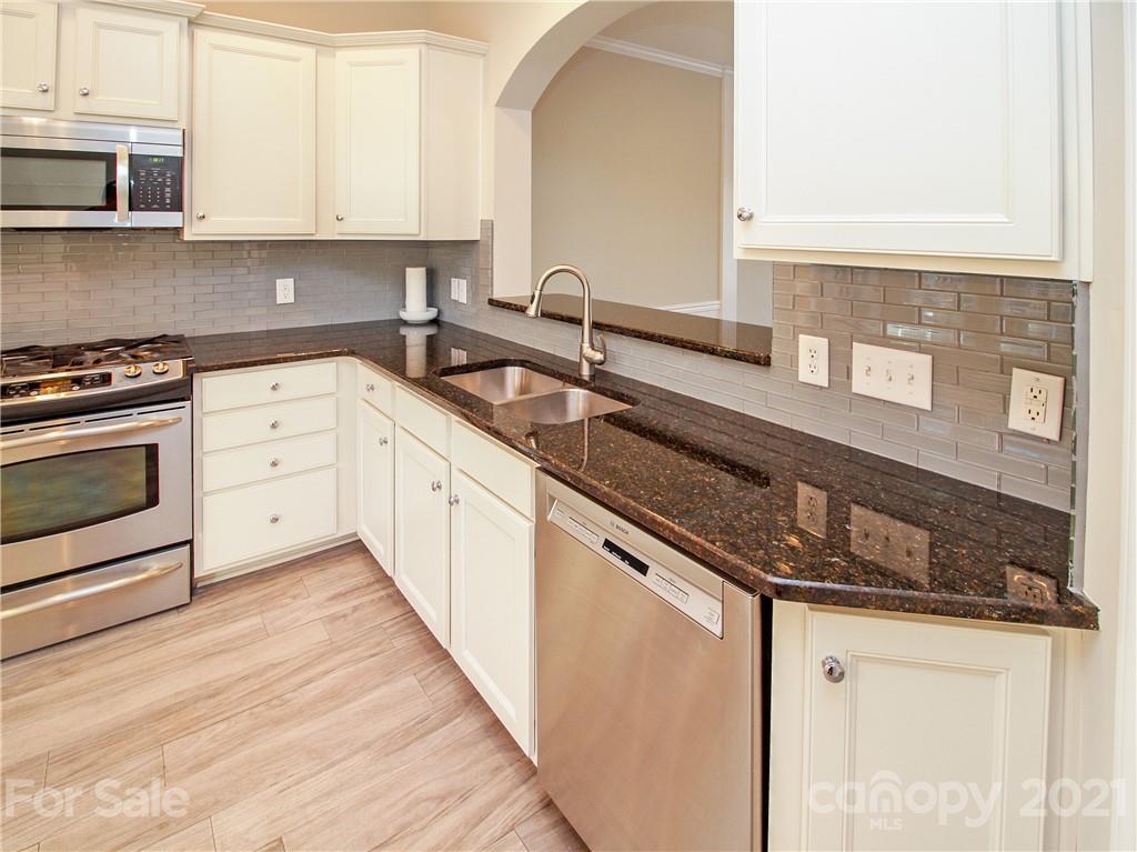 629 6th Baxter Crossing Fort Mill, SC 29708 - Photo 7 of 31 a kitchen with stainless steel appliances granite countertop a sink stove and cabinets