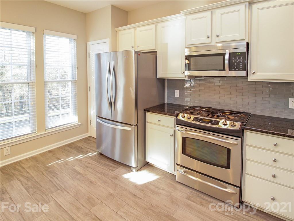 629 6th Baxter Crossing Fort Mill, SC 29708 - Photo 8 of 31 a kitchen with granite countertop a stove microwave and refrigerator