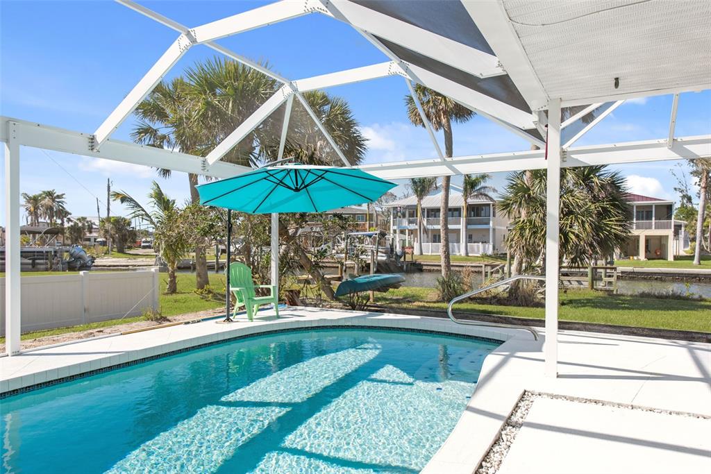 840 Park Road Englewood, FL 34223 - Photo 16 of 76 a view of a patio with swimming pool table and chairs
