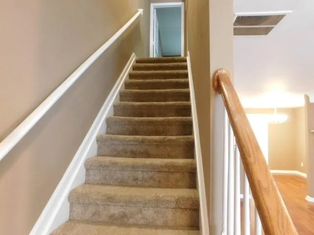 a view of staircase with white walls and windows