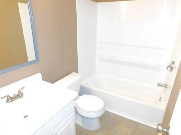 a white toilet sitting next to a white tub