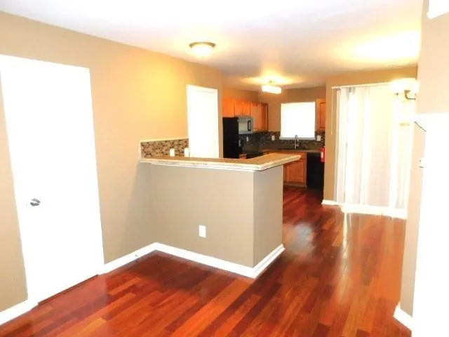 a view of a kitchen with wooden floor and a sink