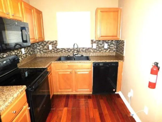 a view of a kitchen with a sink and wooden floor