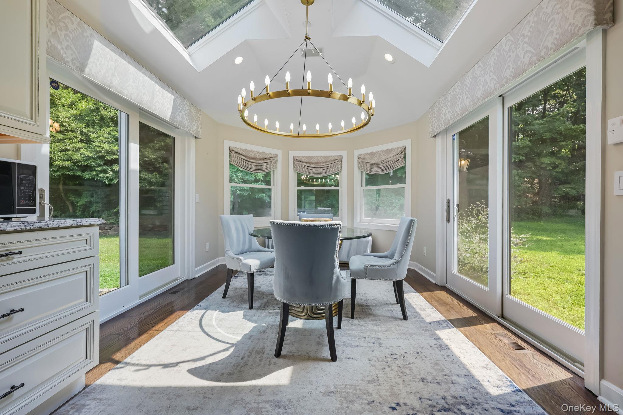 777 Armonk Road Mount Kisco, NY 10549 - Photo 13 of 44 Sunroom featuring a chandelier, a skylight, wood finished floors, and recessed lighting