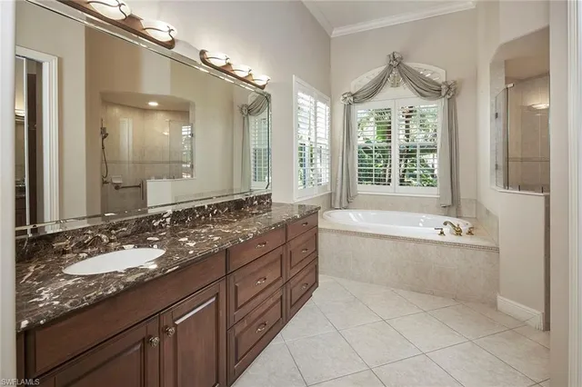 a spacious bathroom with a granite countertop tub sink and mirror