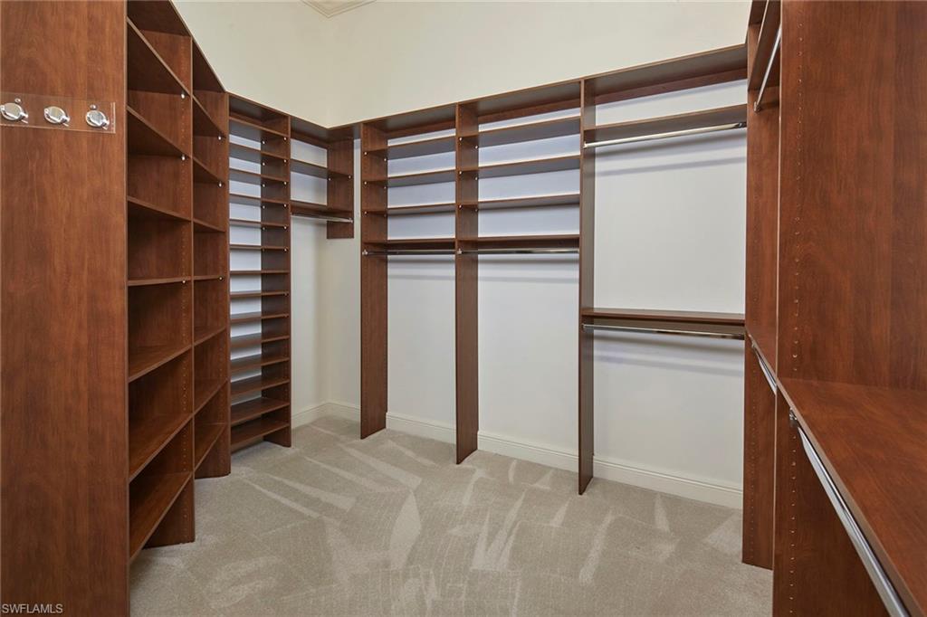 5669 Sago Court Naples, FL 34119 - Photo 14 of 41 Her walk-in closet with light carpet and custom shelving