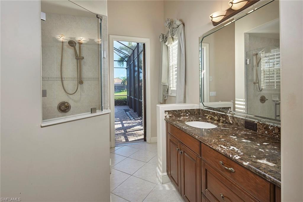 5669 Sago Court Naples, FL 34119 - Photo 15 of 41 His bathroom featuring a stall shower, vanity, and light tile floors