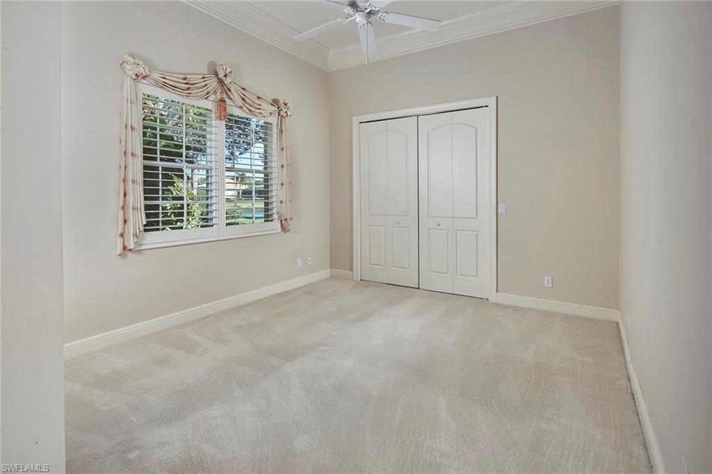 5669 Sago Court Naples, FL 34119 - Photo 20 of 41 Bedroom featuring crown molding, carpet, a closet, and a ceiling fan