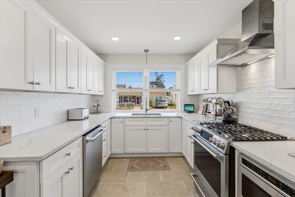 a kitchen with a sink stove top oven and cabinets